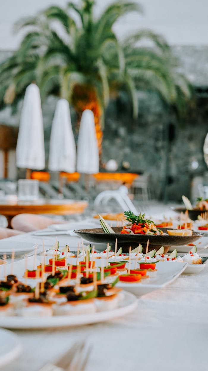 our-experience A beautifully set table with various gourmet finger foods at an outdoor party.