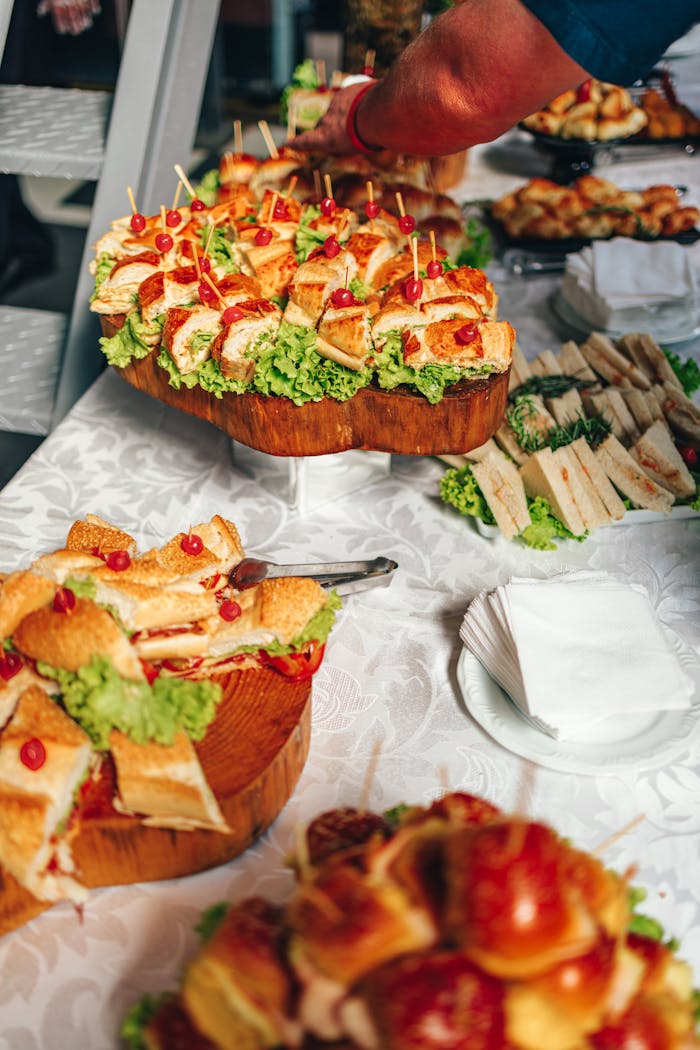 services-04 Close-up of a vibrant sandwich buffet with fresh lettuce and garnish on a tablecloth.